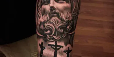 Tätowierung eines Jesusgesichts auf dem Arm