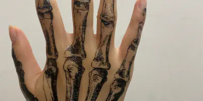 Arm Tattoo mit einer Skeletthand