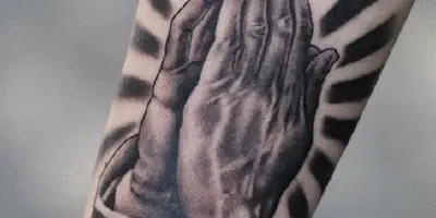 Betende Hände Tattoo auf dem Arm